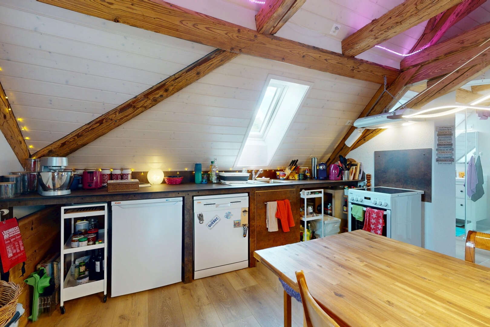 kitchen featuring white appliances, light wood-type flooring, and a skylight