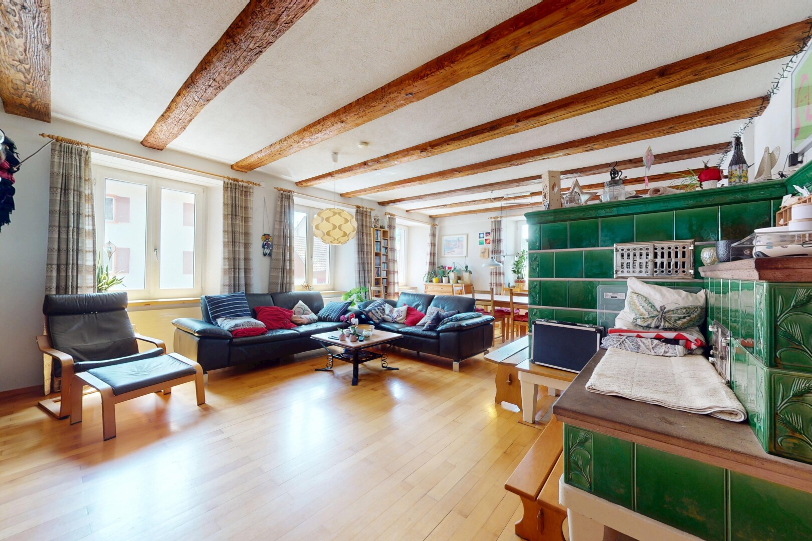living room featuring beamed ceiling, healthy amount of natural light, and wood finished floors