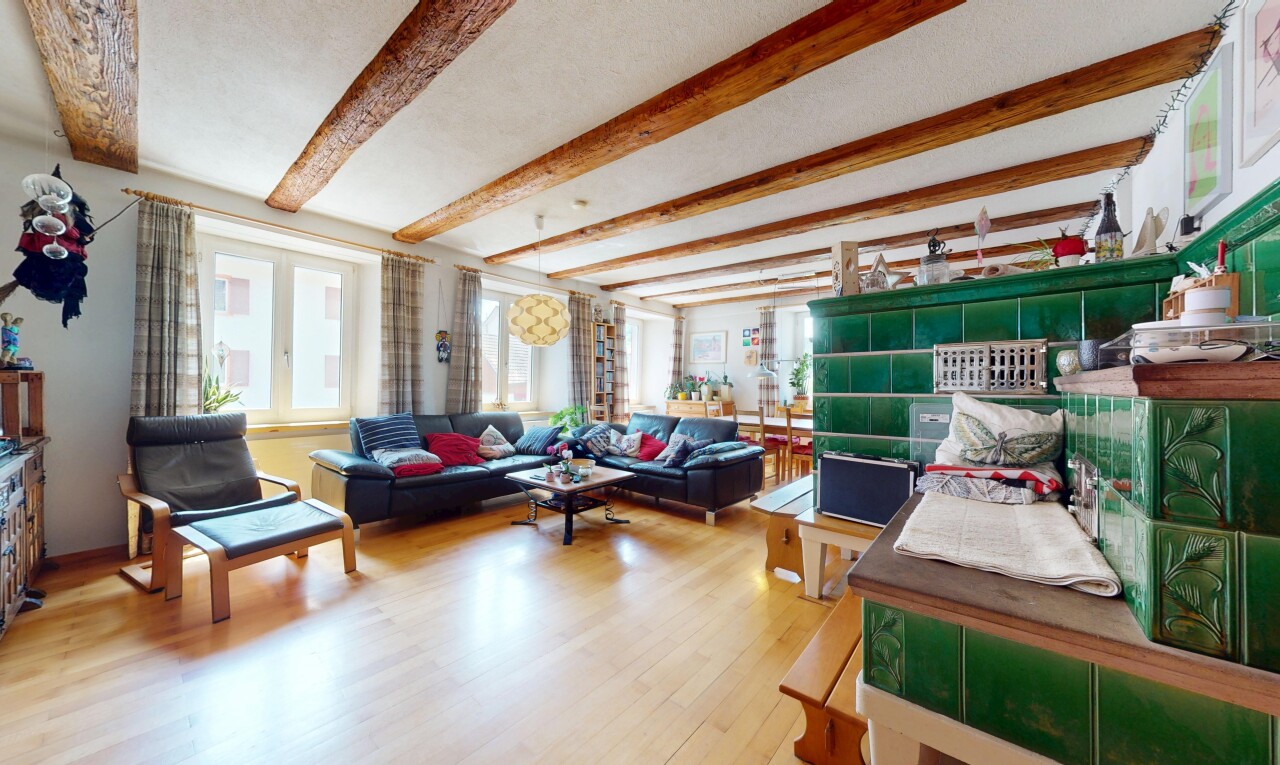 living room featuring beamed ceiling, healthy amount of natural light, and wood finished floors