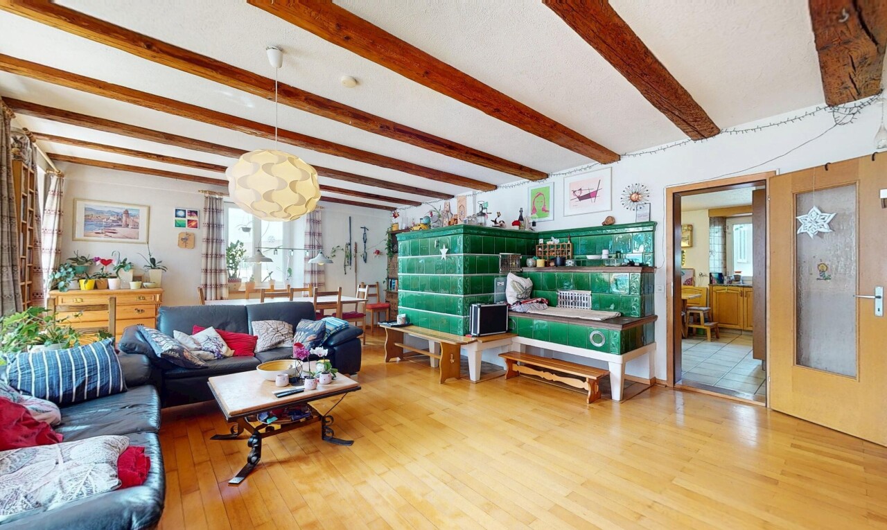 living room featuring beam ceiling, wood finished floors, and plenty of natural light