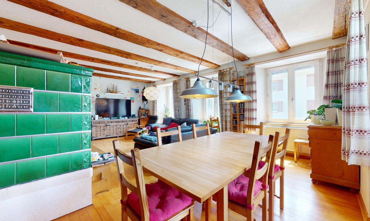dining space with light wood finished floors and beam ceiling