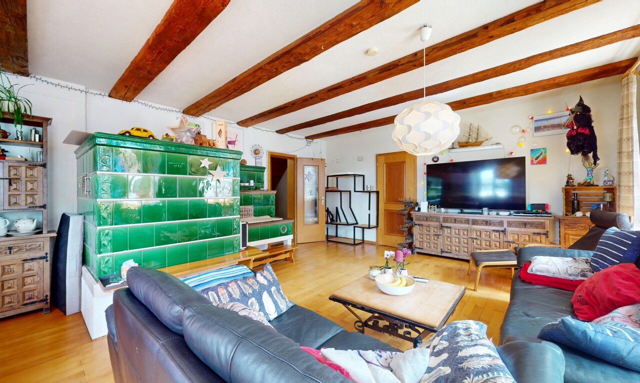 living area with wood finished floors and beam ceiling