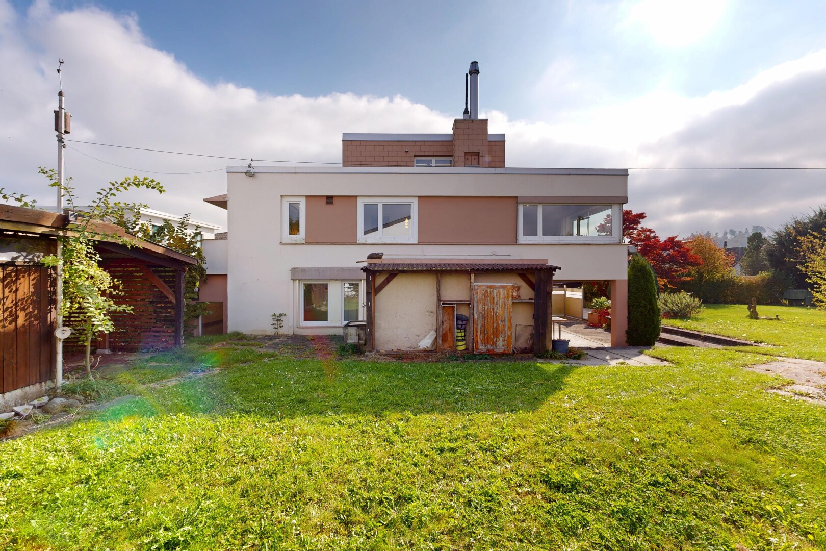 façade avec bardage en stuc, pelouse, property visible, terrasse, et power lines view