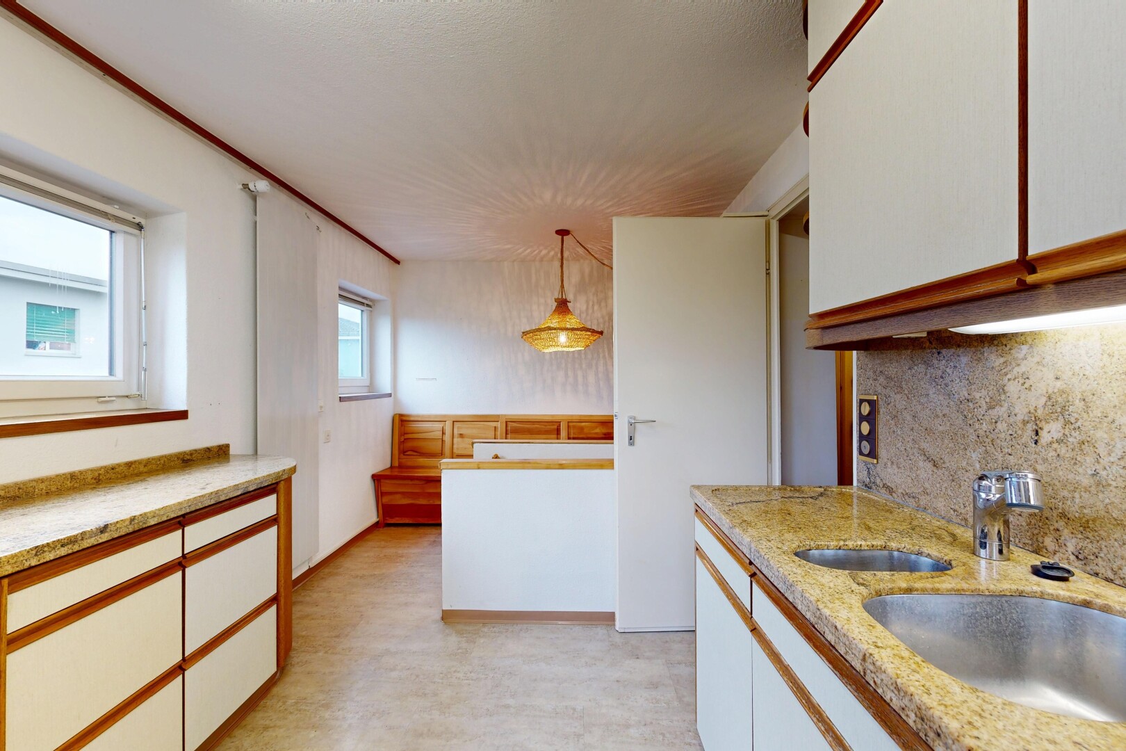 cuisine avec armoires blanches, dosseret, backsplash, éclairage suspendu, et inside property
