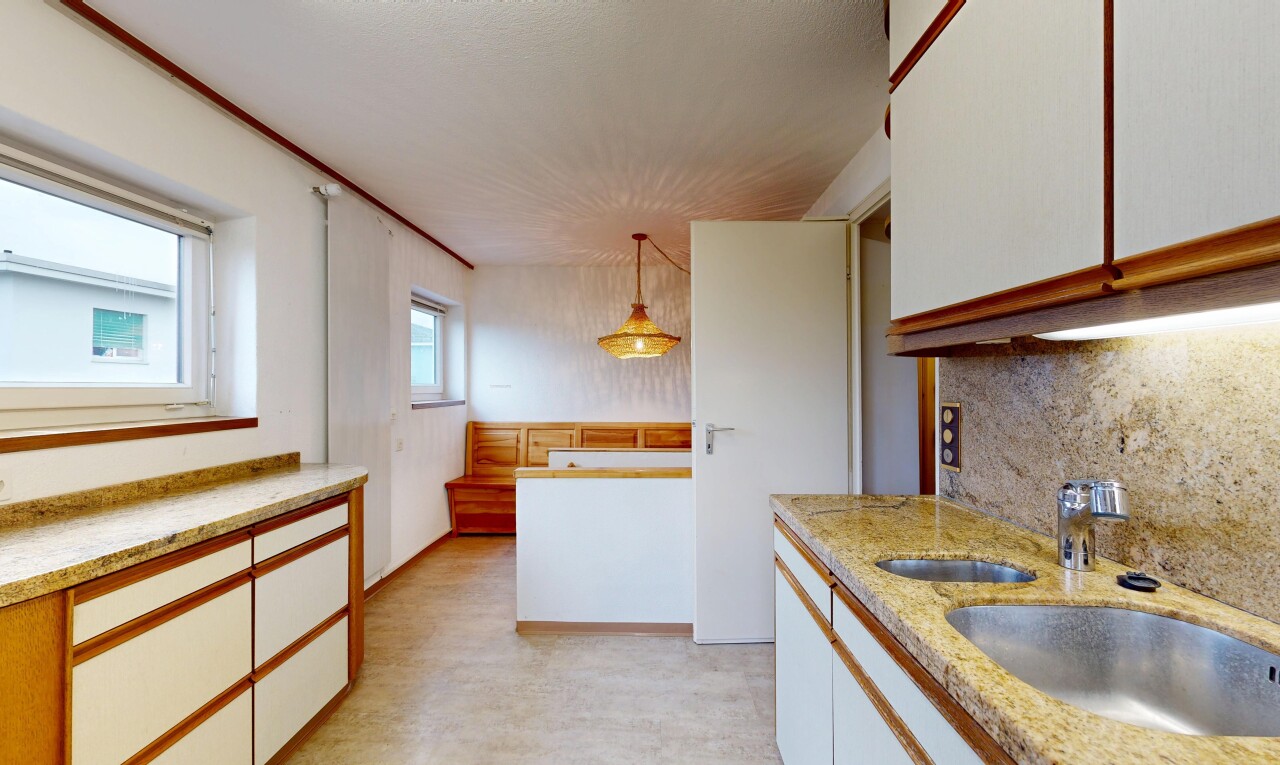 cuisine avec armoires blanches, dosseret, backsplash, éclairage suspendu, et inside property