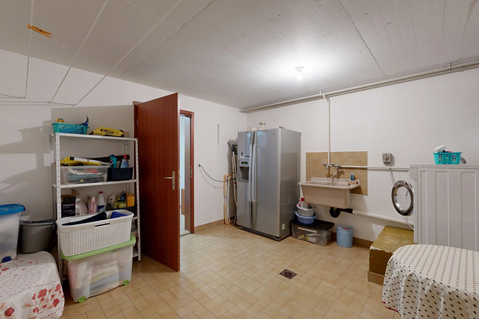 buanderie avec cloison sèche, drywall, inside property, évier, et light floor