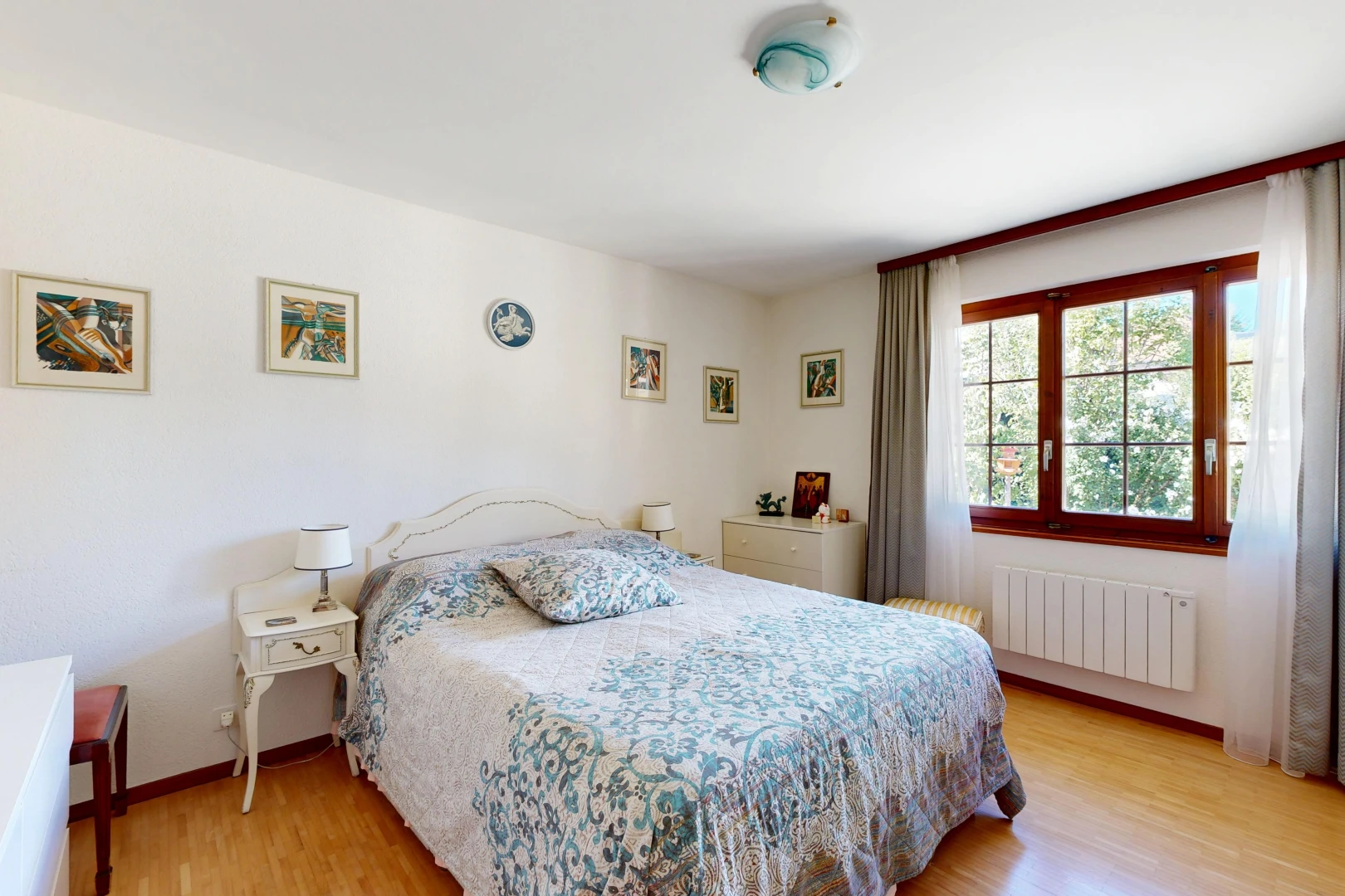 chambre avec radiateur, wood finish floor, sol en finition bois, drywall, et cloison sèche