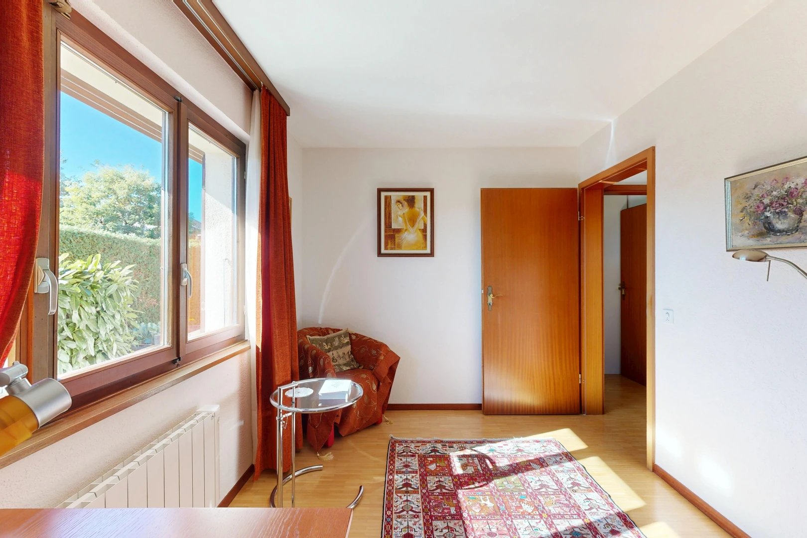 couloir avec radiateur, cloison sèche, drywall, sol en finition bois, et wood finish floor