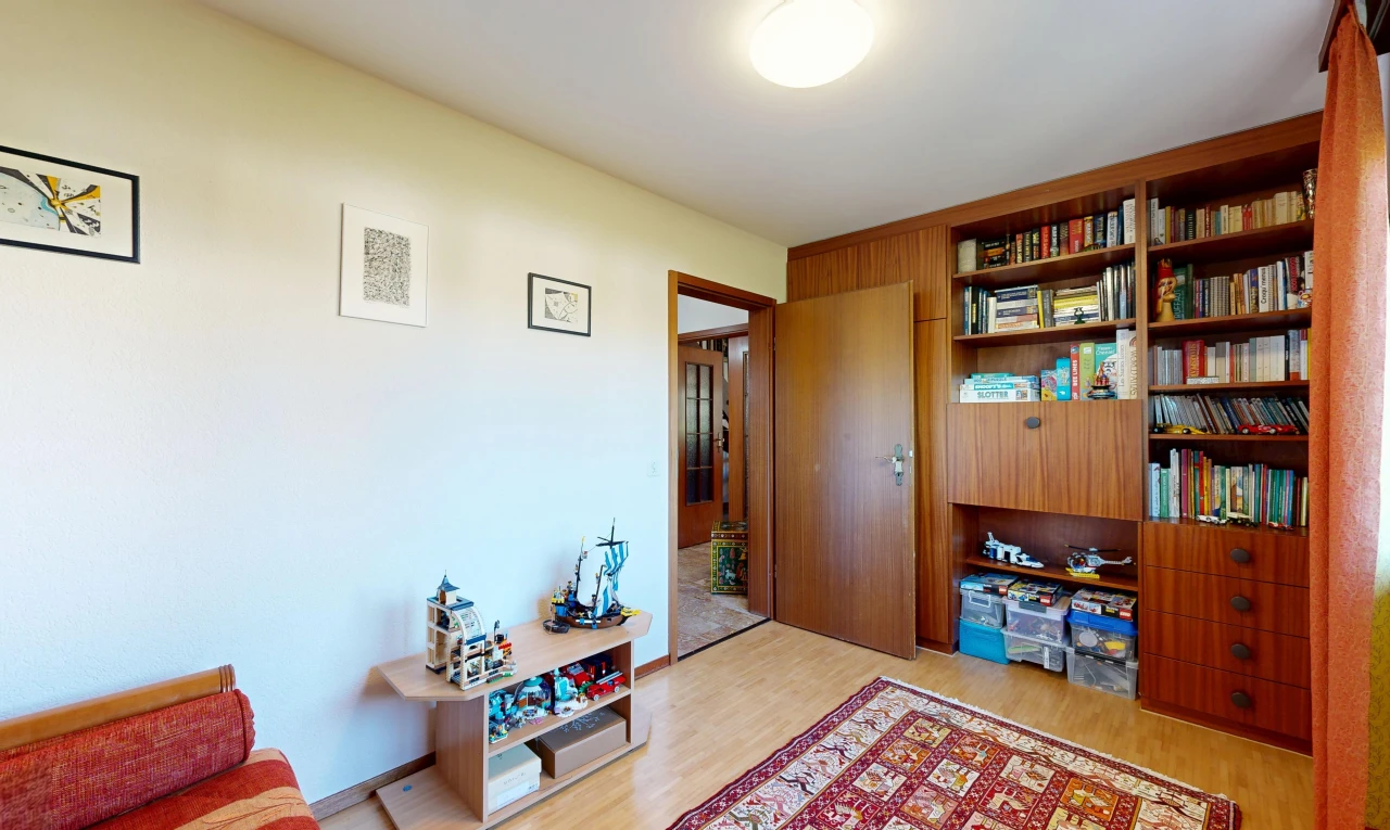 salon avec drywall, cloison sèche, wood finish floor, sol en finition bois, et étagères intégrées