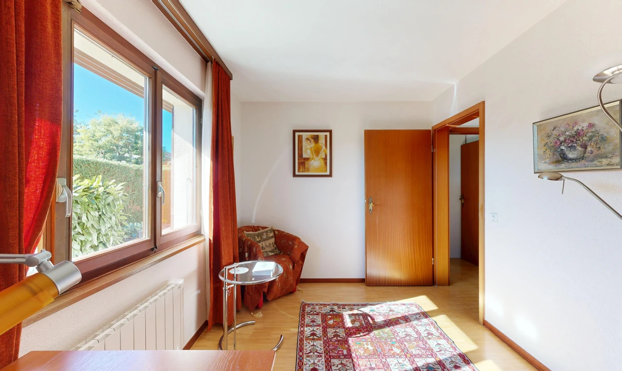 couloir avec radiateur, cloison sèche, drywall, sol en finition bois, et wood finish floor