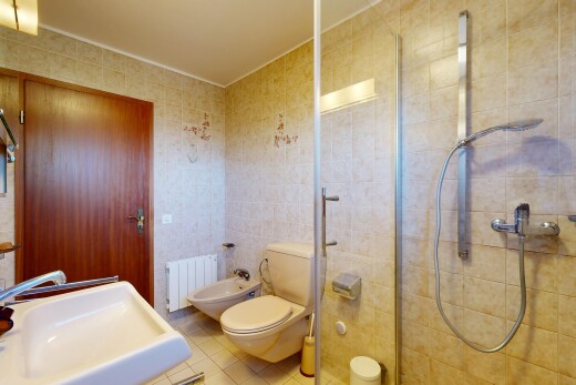 bathroom featuring a stall shower, tile walls, radiator heating unit, a bidet, and light tile patterned floors