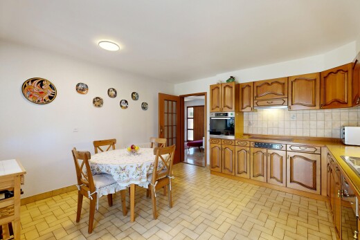 kitchen featuring wood finish cabinetry, tasteful backsplash, brick patterned floors, light countertops, and stainless steel oven