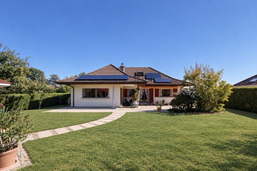 outdoor house featuring roof mounted solar panels, a yard, a tile roof, a chimney, and a patio