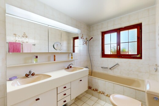 full bathroom with double vanity, light tile patterned floors, tile walls, and tiled shower / bath