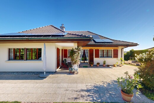 view of home with a tiled roof, roof mounted solar panels, and stucco siding