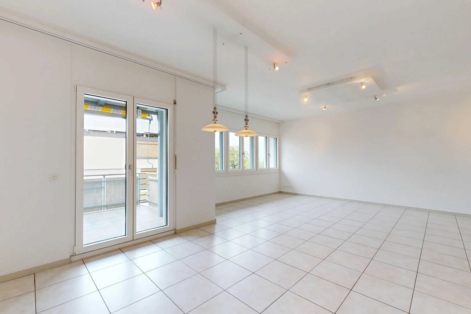 pièce vide avec éclairage sur rail, accès à l'extérieur, light floor, drywall, et cloison sèche