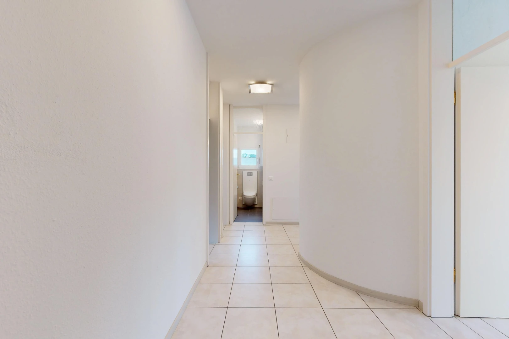 couloir avec light floor, tile floor, sol en carrelage, et inside property
