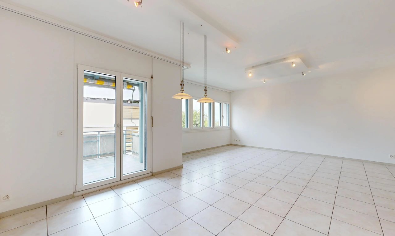 pièce vide avec éclairage sur rail, accès à l'extérieur, light floor, drywall, et cloison sèche