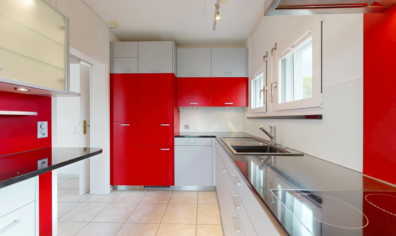 cuisine avec two tone kitchen, éclairage sur rail, light floor, évier, et plaque de cuisson