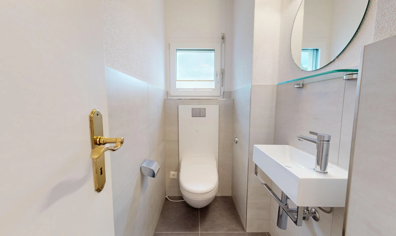 salle de bains avec toilette, miroir, tile wall, mur en carrelage, et inside property