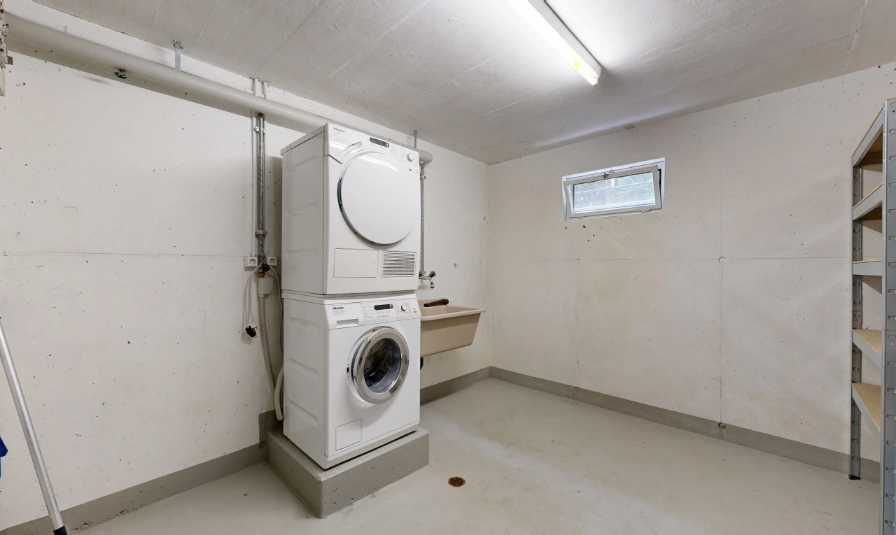 buanderie avec lave-linge et sèche-linge superposés, lumière naturelle, sous-sol, inside community, et buanderie