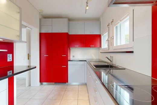 cuisine avec two tone kitchen, éclairage sur rail, light floor, évier, et plaque de cuisson