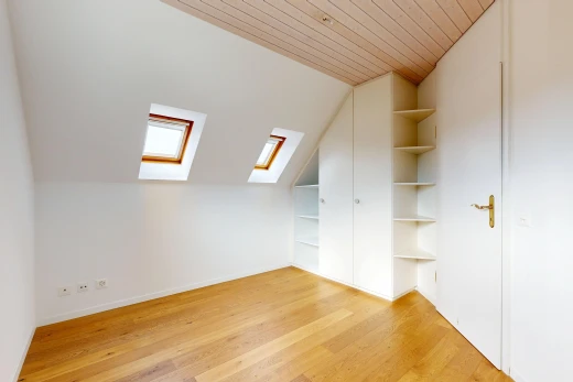 pièce vide avec puits de lumière, vaulted ceiling, plafond voûté, étagères intégrées, et pièce supplémentaire