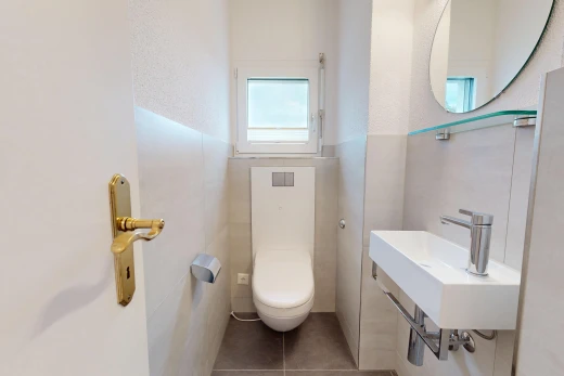 salle de bains avec toilette, miroir, tile wall, mur en carrelage, et inside property