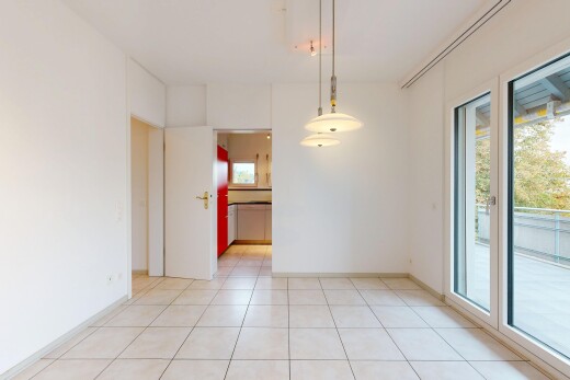 unfurnished room with access to outside, light tile patterned floors, and hanging light fixtures
