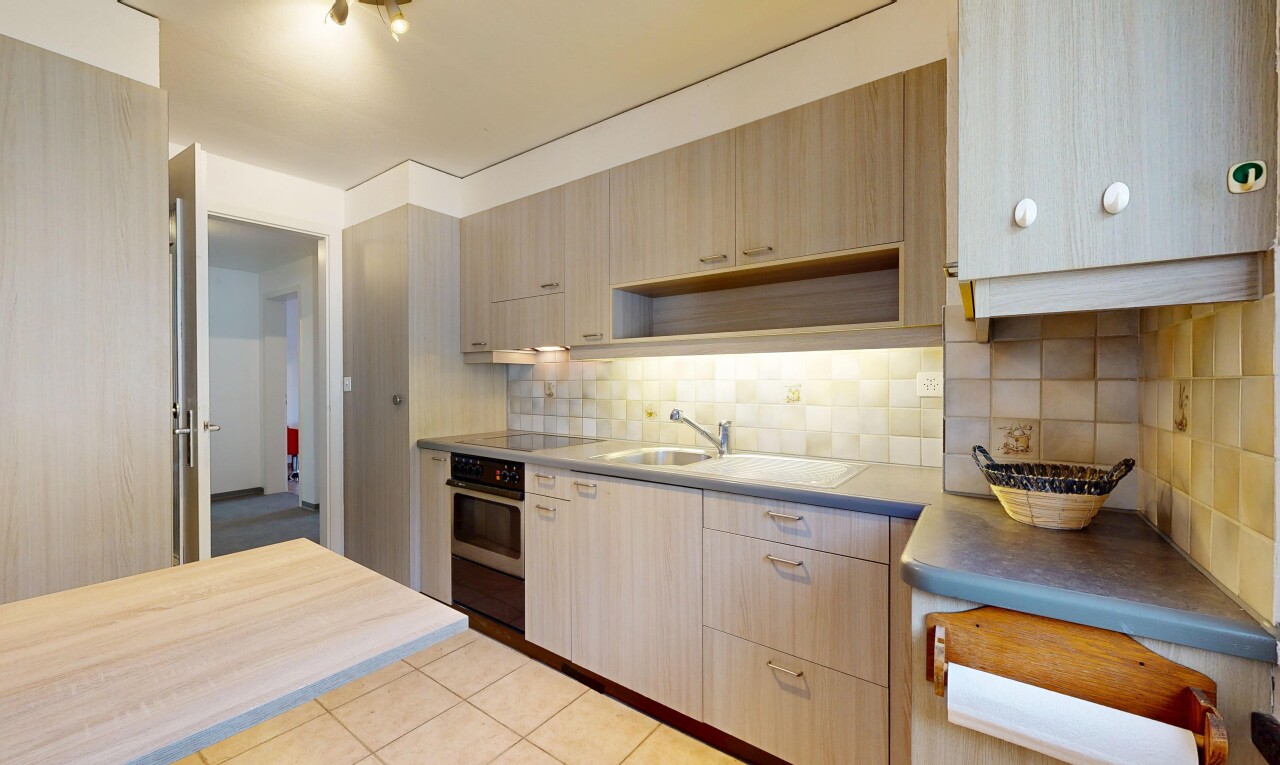 kitchen featuring decorative backsplash, wall oven, light countertops, and light brown cabinetry