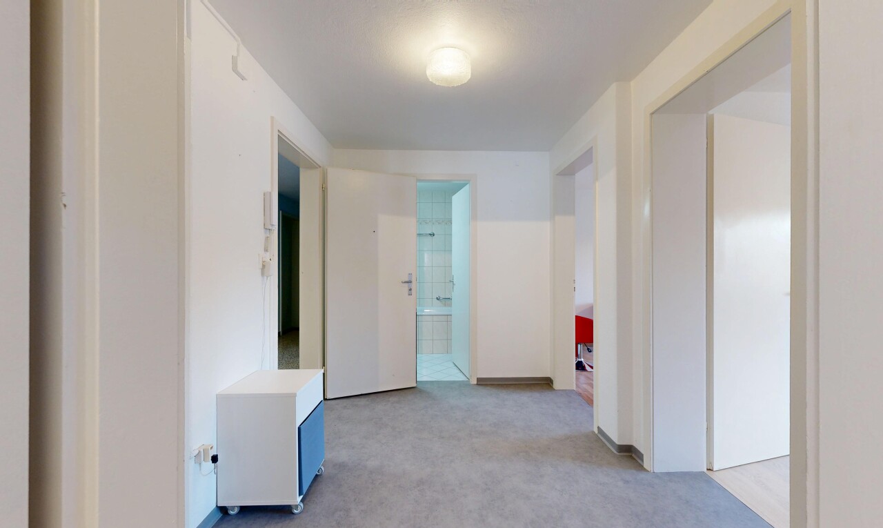 hall with light colored carpet