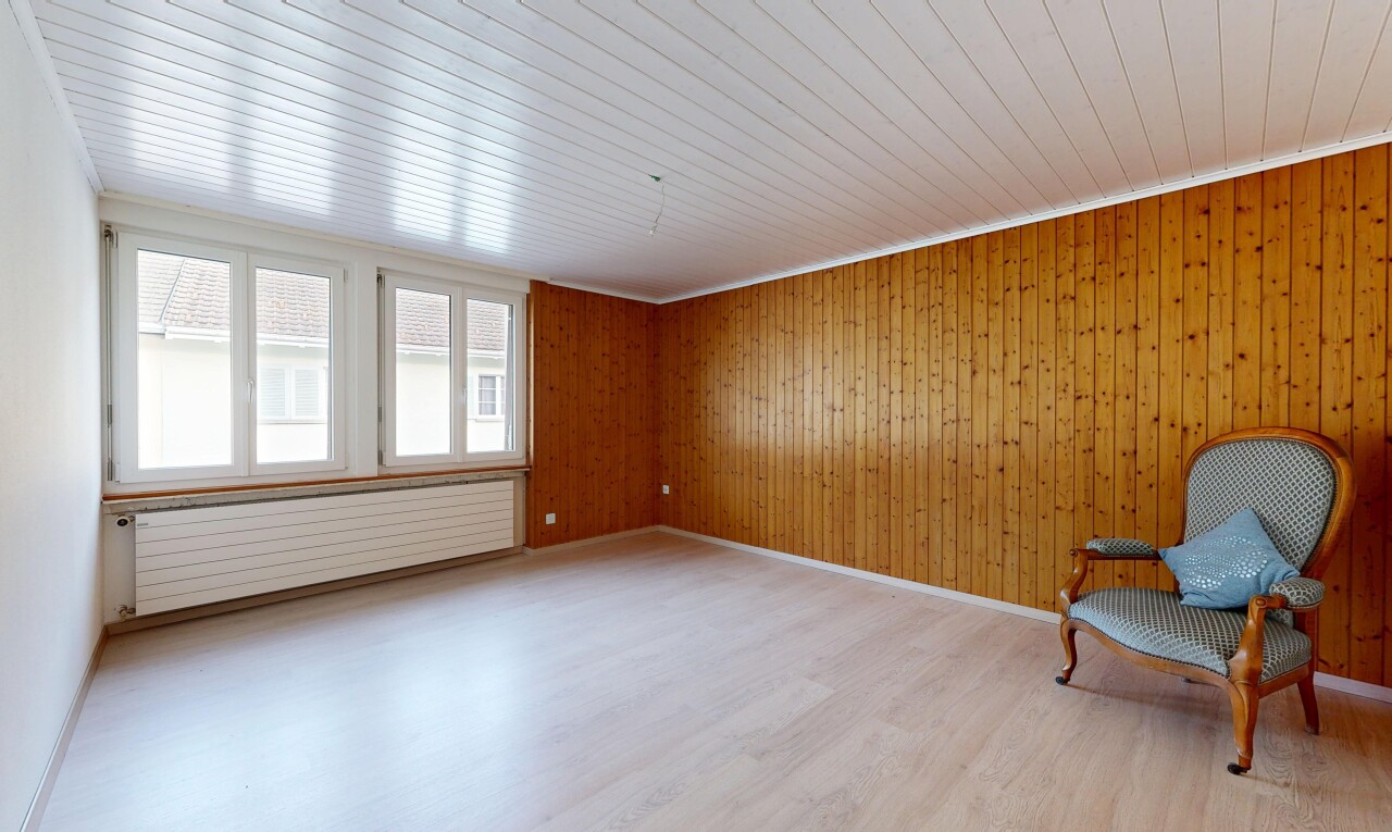 empty room with light wood finished floors, radiator, wood walls, and wood ceiling