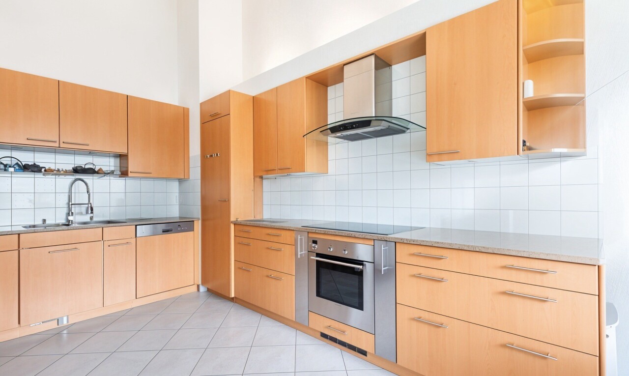 cuisine avec hotte, armoires marron clair, tile floor, backsplash, et inside property