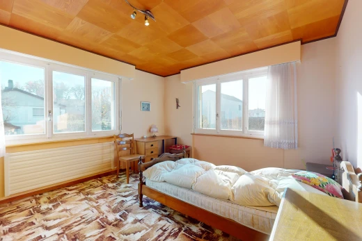 chambre avec plafond de bois et lumière naturelle