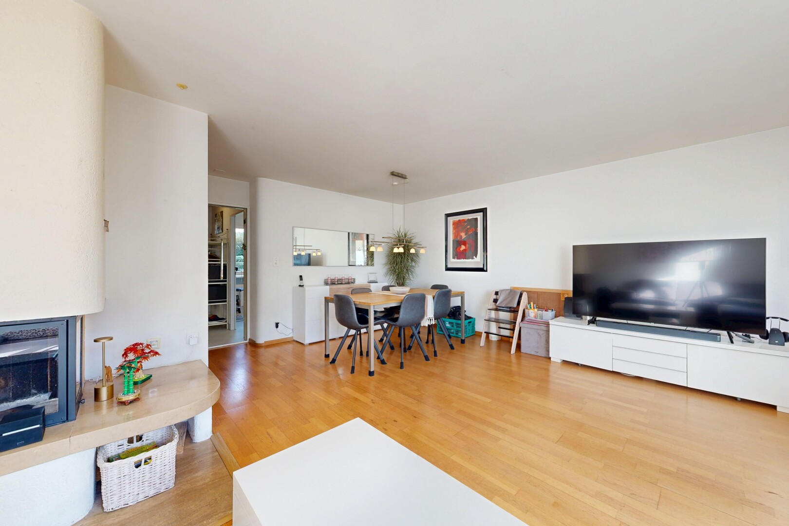 wohn- / esszimmer mit fernseher, holzfußboden, wood finish floor, inside property, und gipskartonwand