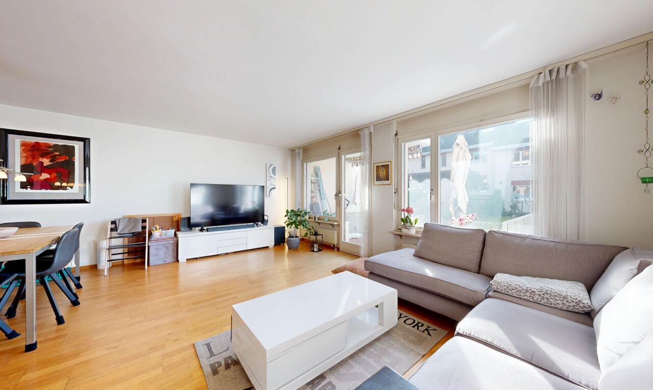 wohnzimmer mit fernseher, holzfußboden, wood finish floor, inside property, und natürliches licht