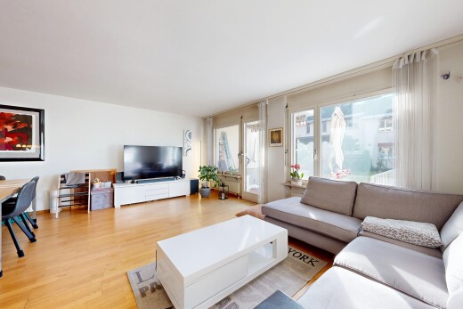 wohnzimmer mit fernseher, holzfußboden, wood finish floor, inside property, und natürliches licht