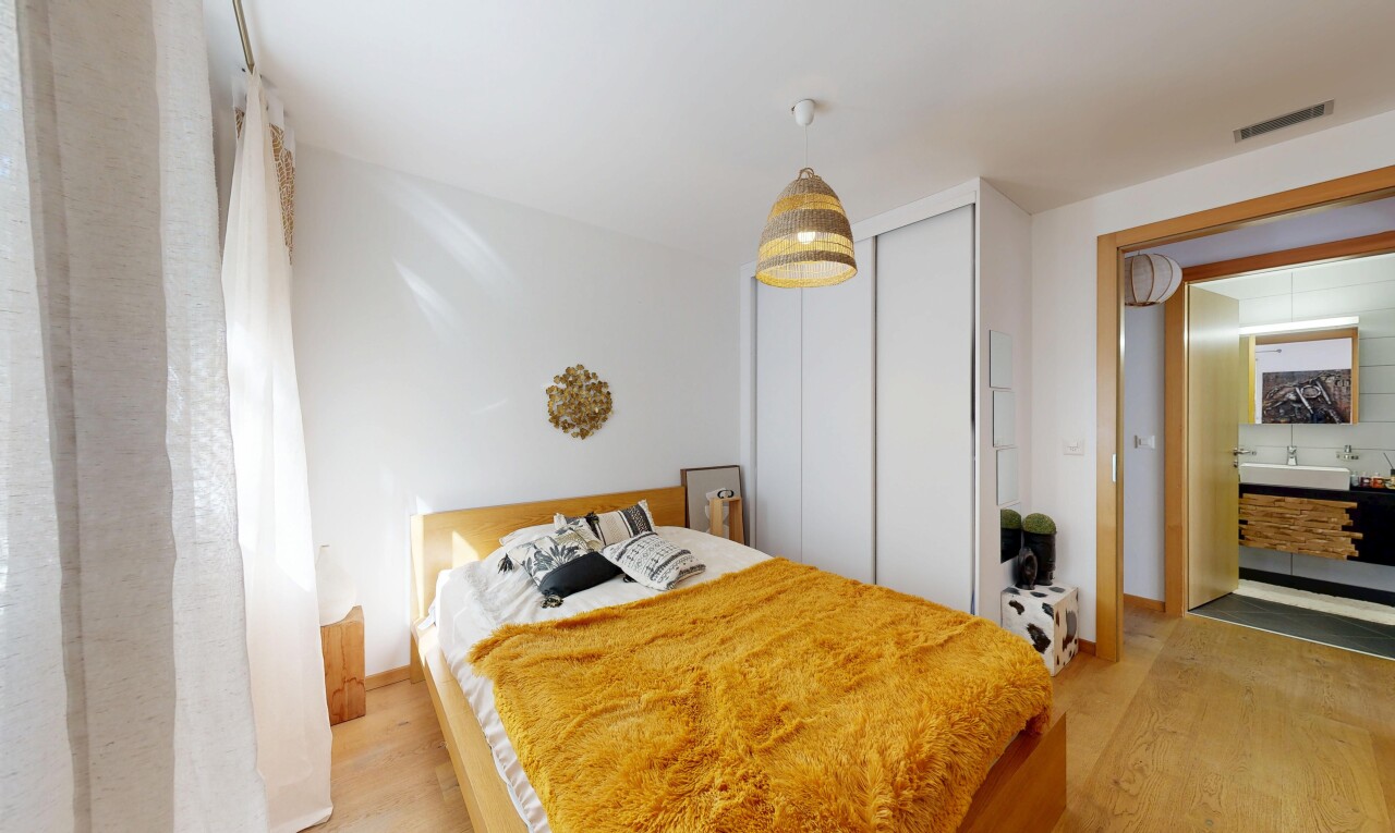 zimmer / schlafzimmer mit kleiderschrank, drywall, gipskartonwand, pendelleuchte, und wood finish floor