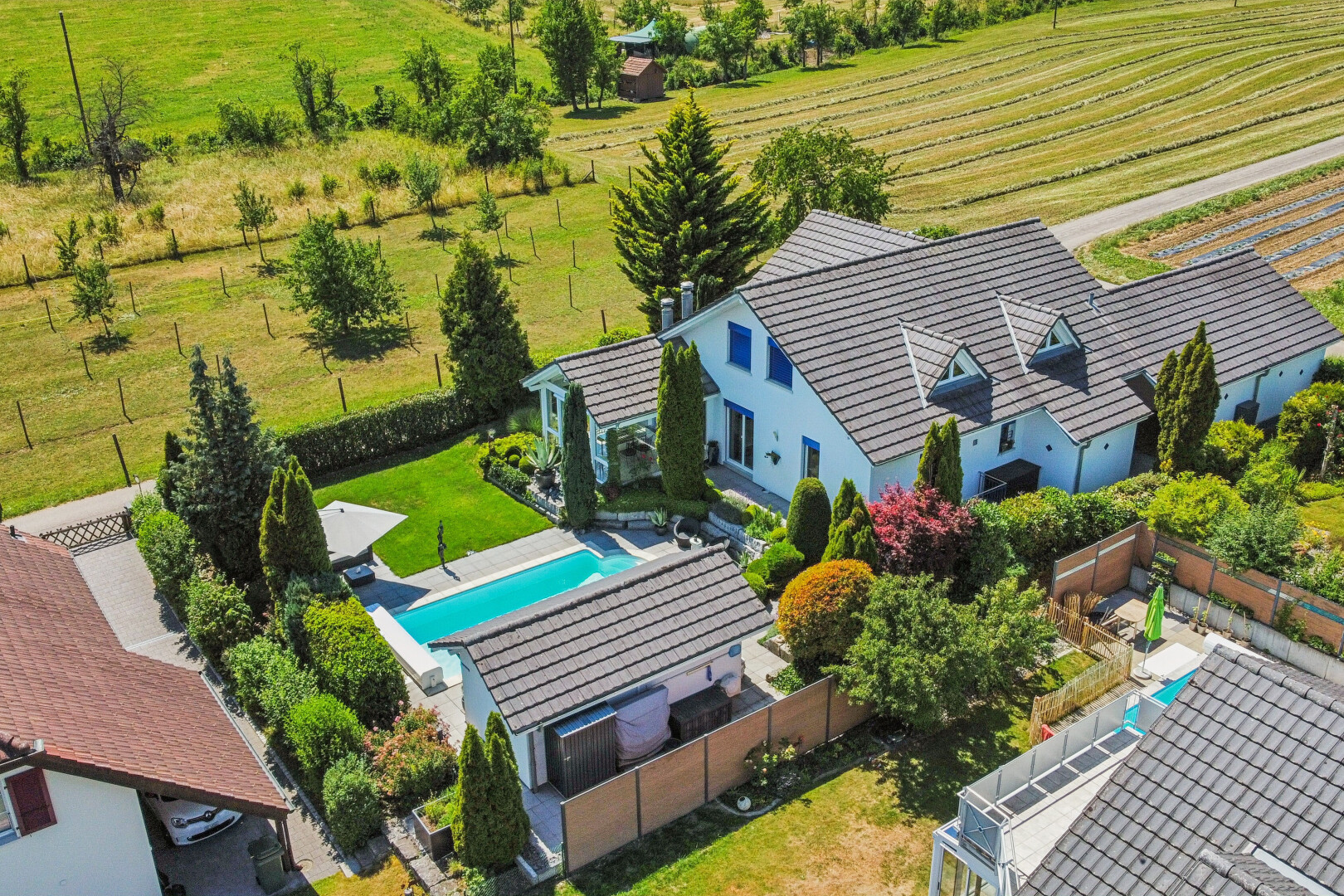 außenansicht mit zaun, schwimmbad, property visible, rasen, und terrasse