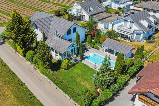 view of property with a pergola, an outdoor pool, a patio area, agricultural area, and a lawn