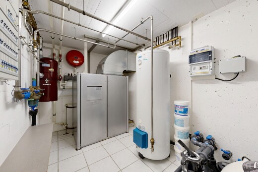 laundry area with water heater and light tile patterned floors