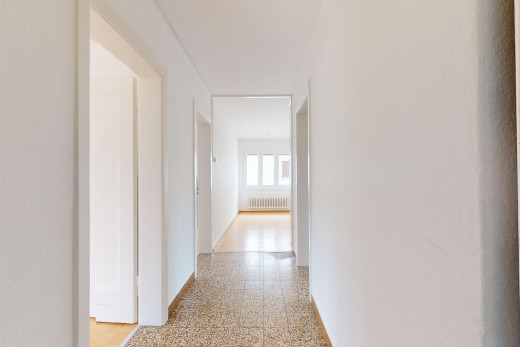 couloir avec sol en agrégat, lumière naturelle, et radiateur