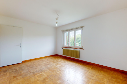 pièce vide avec parquet, radiateur, et lumière naturelle