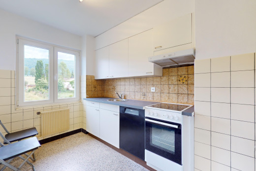 cuisine avec four intégré, lumière naturelle, radiateur, hotte, et crédence