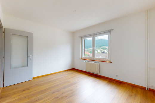 pièce vide avec plancher de bois, lumière naturelle, et radiateur