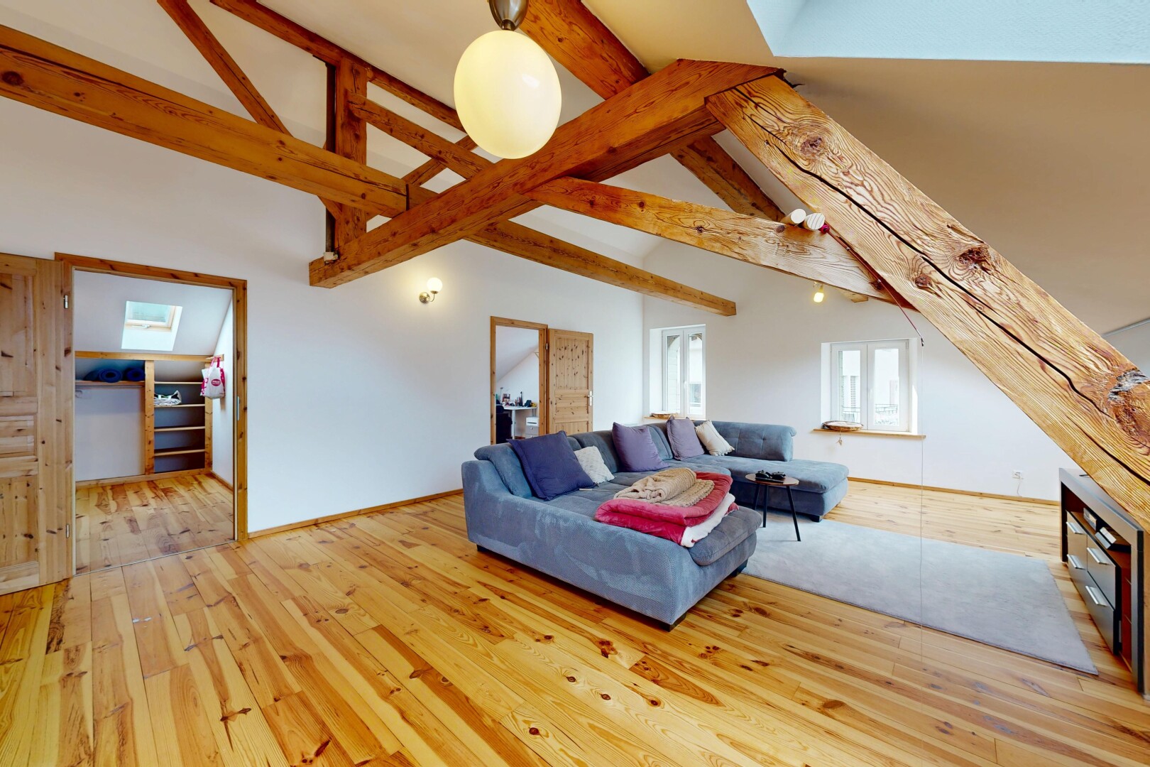 salon avec vaulted ceiling, plafond voûté, beamed ceiling, plafond à poutres, et wood finish floor