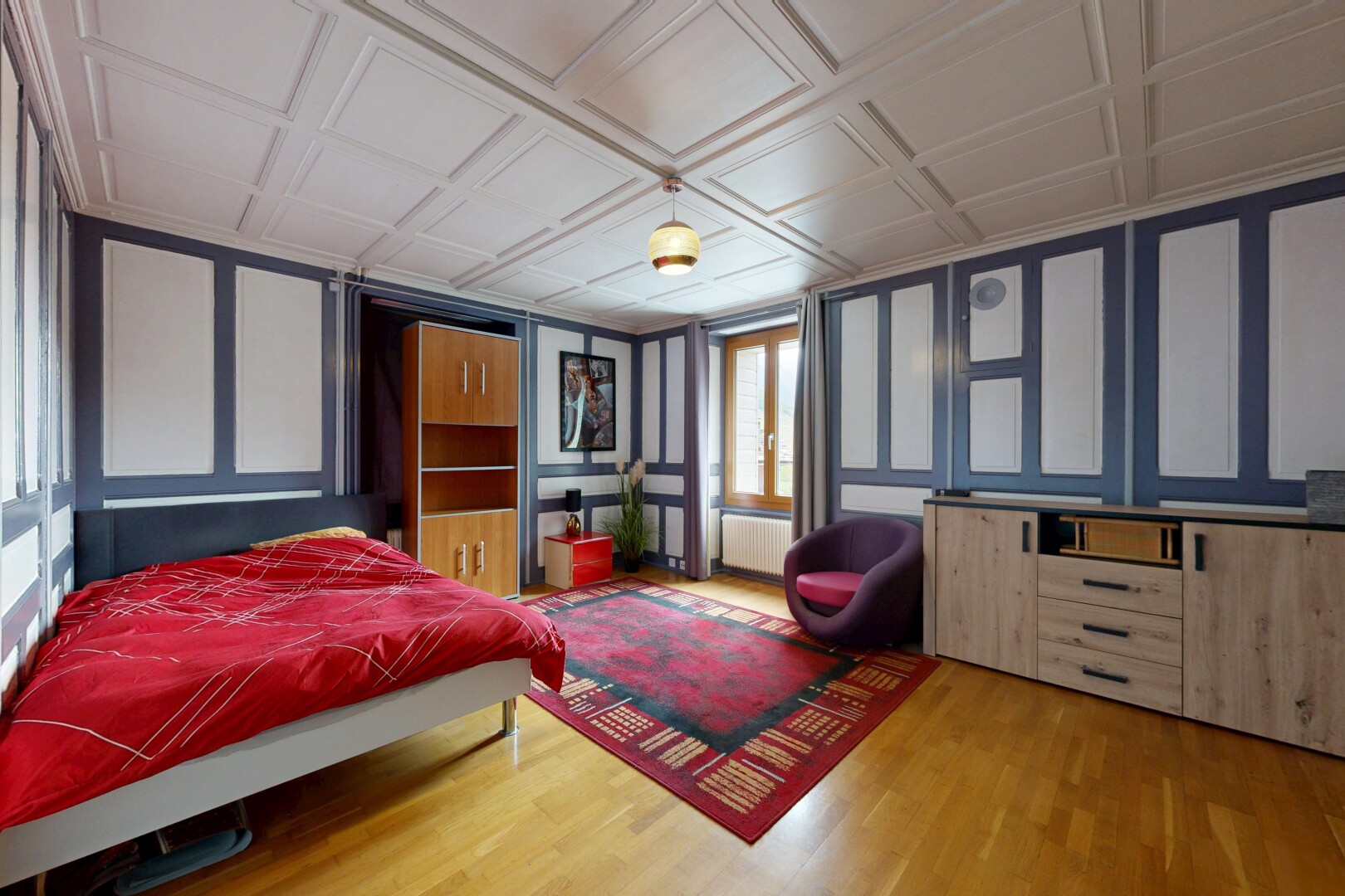 chambre avec paneling wall, mur panneauté, wood finish floor, sol en finition bois, et éclairage suspendu