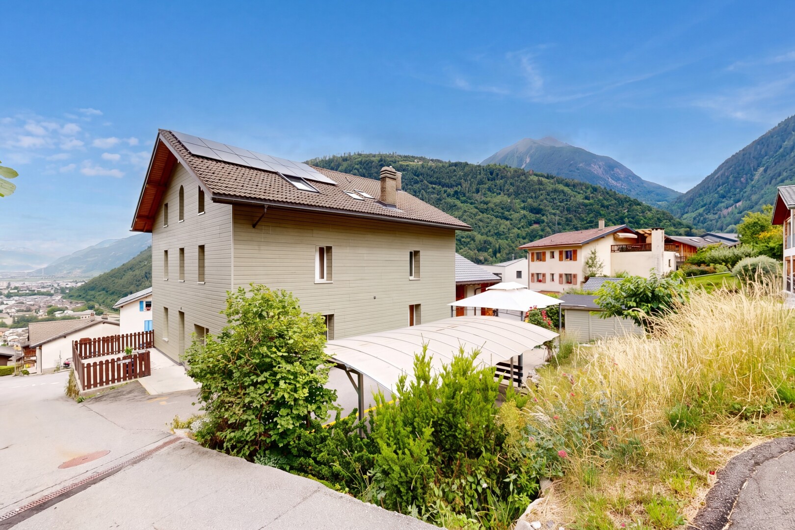 façade avec vue sur la montagne, mountain view, panneaux solaires, cheminée, et bardage horizontal