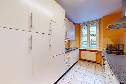kitchen featuring dark countertops, stainless steel microwave, white cabinetry, and electric cooktop