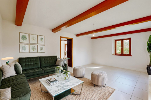 wohnzimmer mit fliesenboden, balkendecke, und natürliches licht